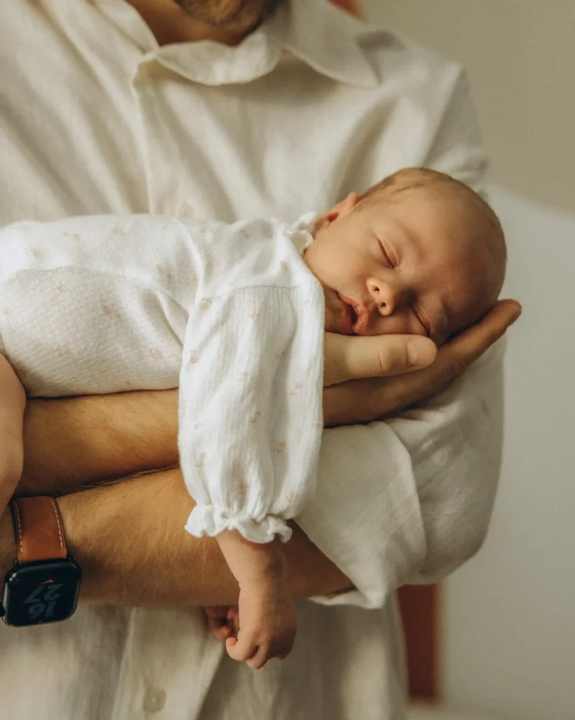 Neugeborenes auf dem Arm des Vaters