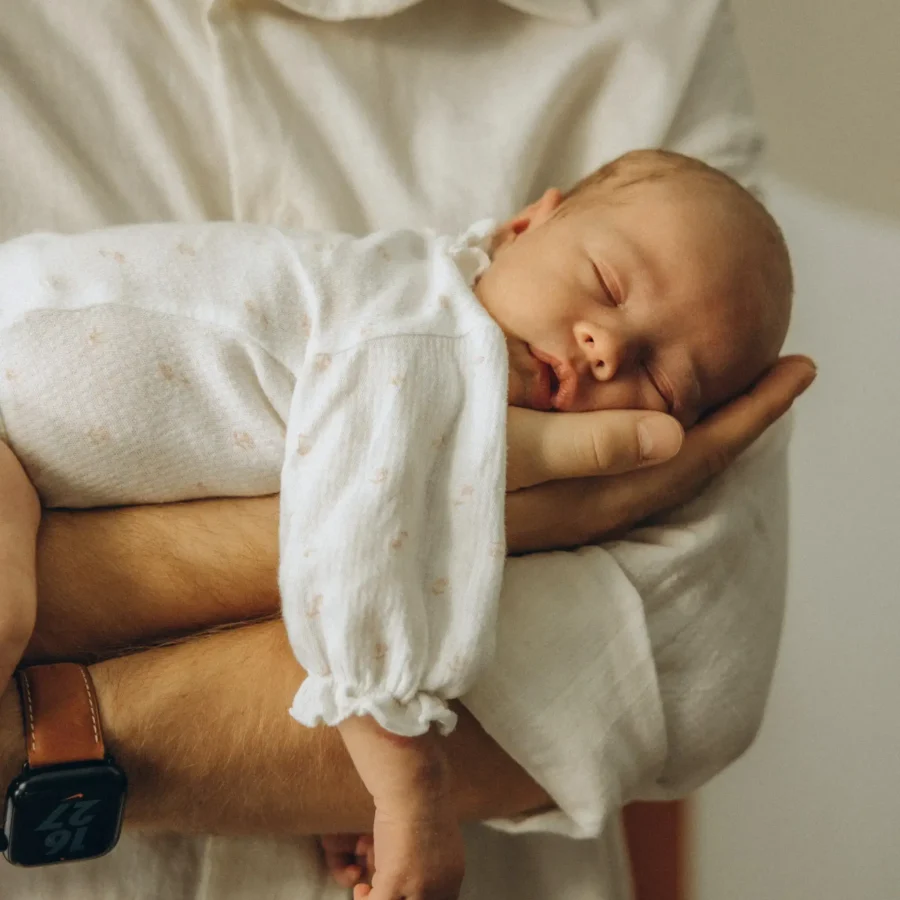 Neugeborenes auf dem Arm des Vaters