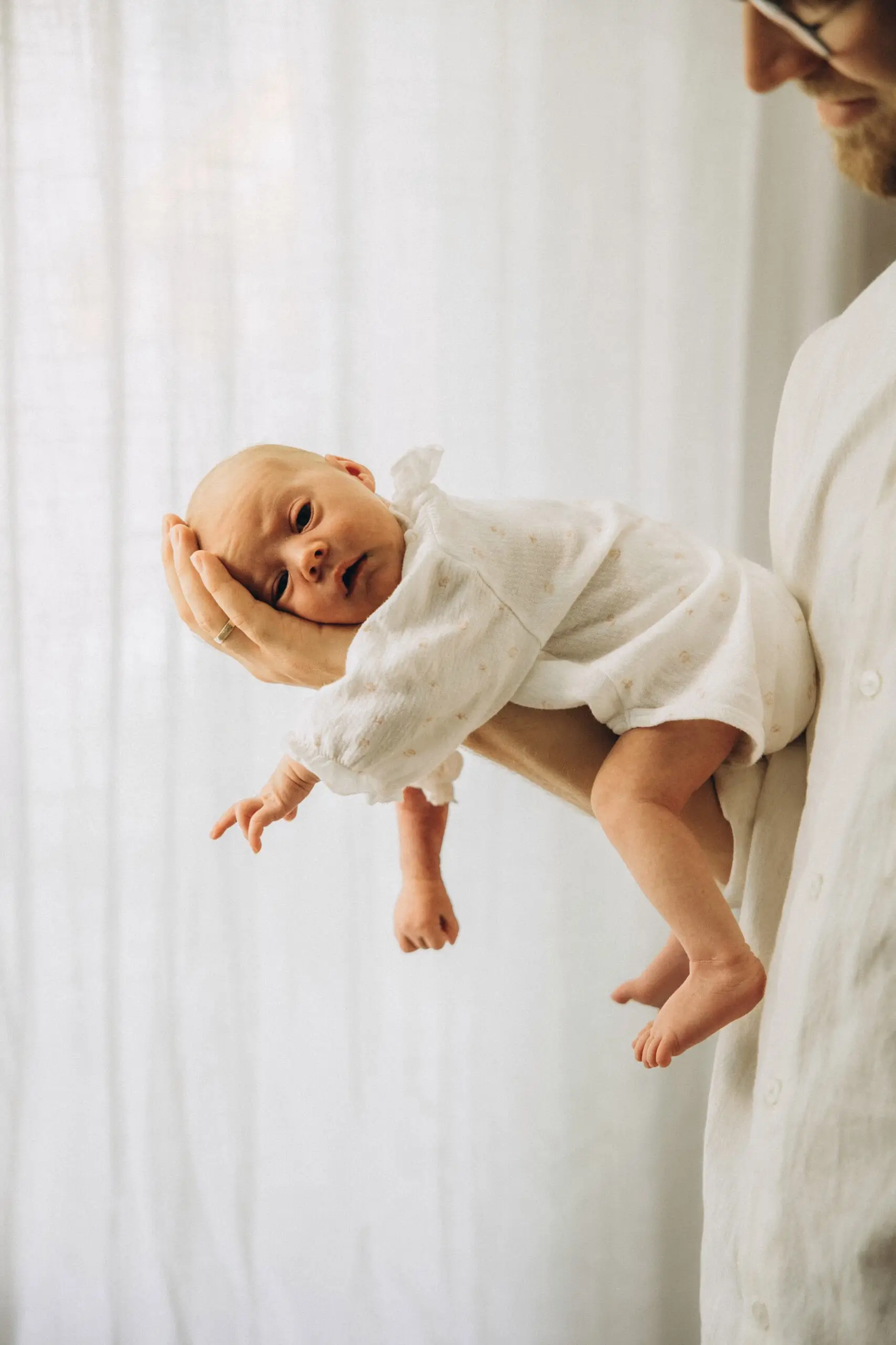 Neugeborenes auf dem Arm des Vaters