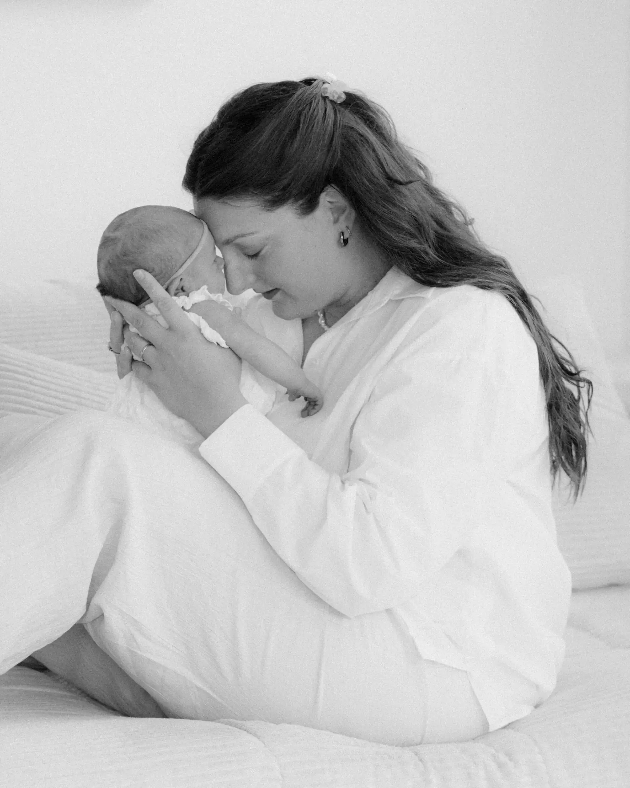 Mutter genießt innige Momente mit ihrer Neugeborenen Tochter bei einem Neugeborenen Shooting in Bayern