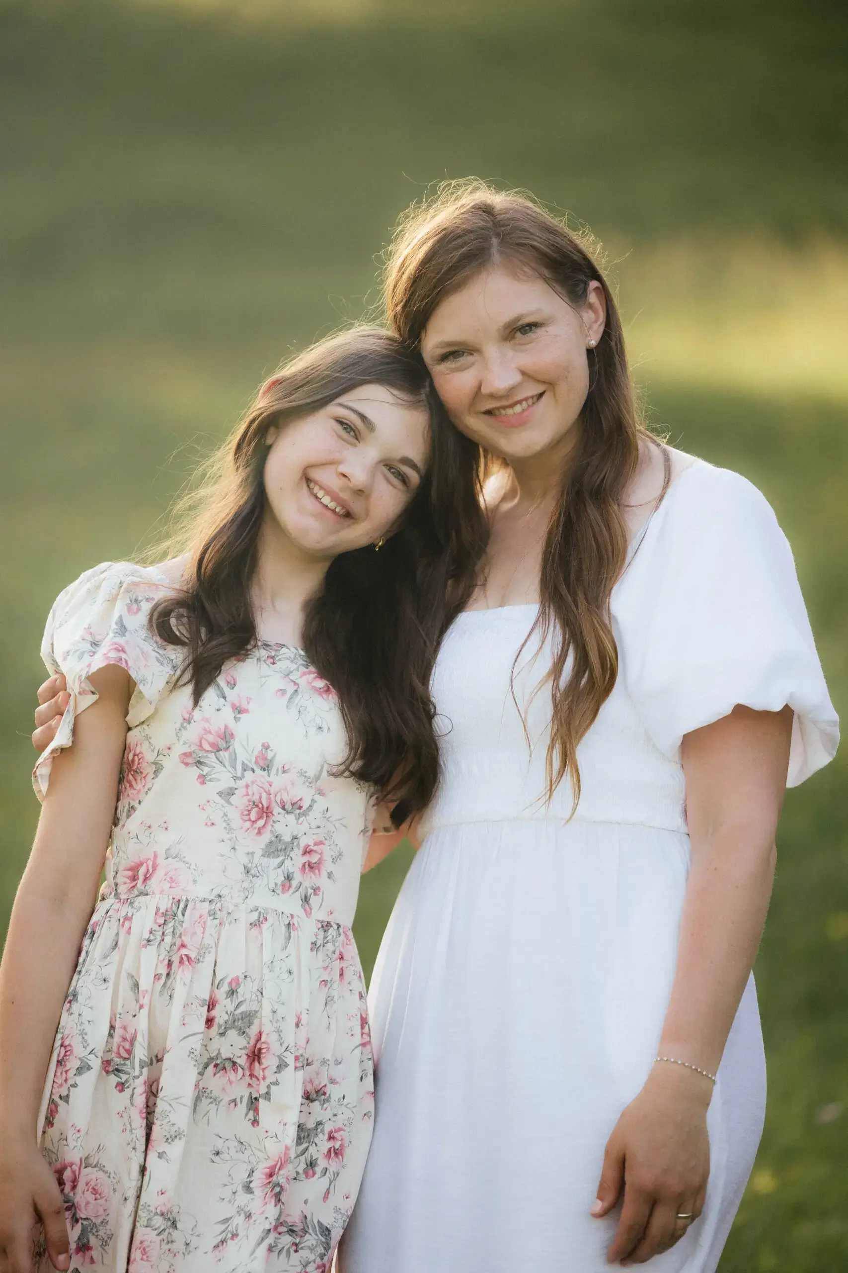 Mutter und Tochter stehen Arm in Arm beim Familienshooting