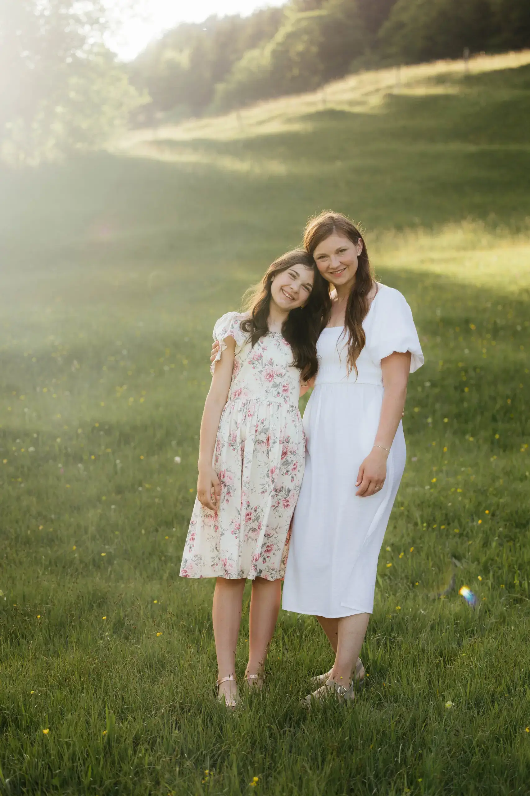 Mutter und Tochter stehen Arm in Arm beim Familienshooting