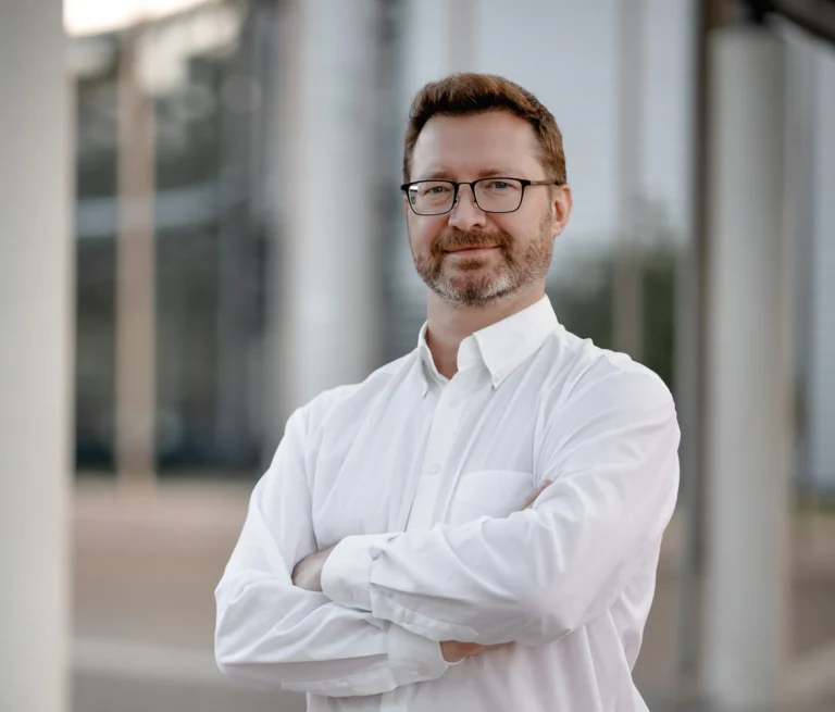 Mann in Hemd vor einem Unternehmensgebäude München