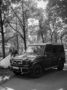 Brautpaar läuft hinter Mercedes