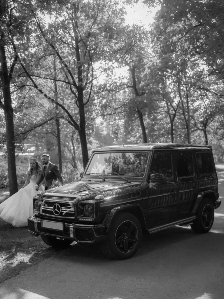 Brautpaar läuft hinter Mercedes