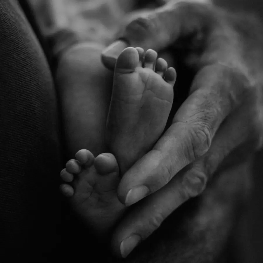 Hände halten Füße von Baby beim Babyshooting München