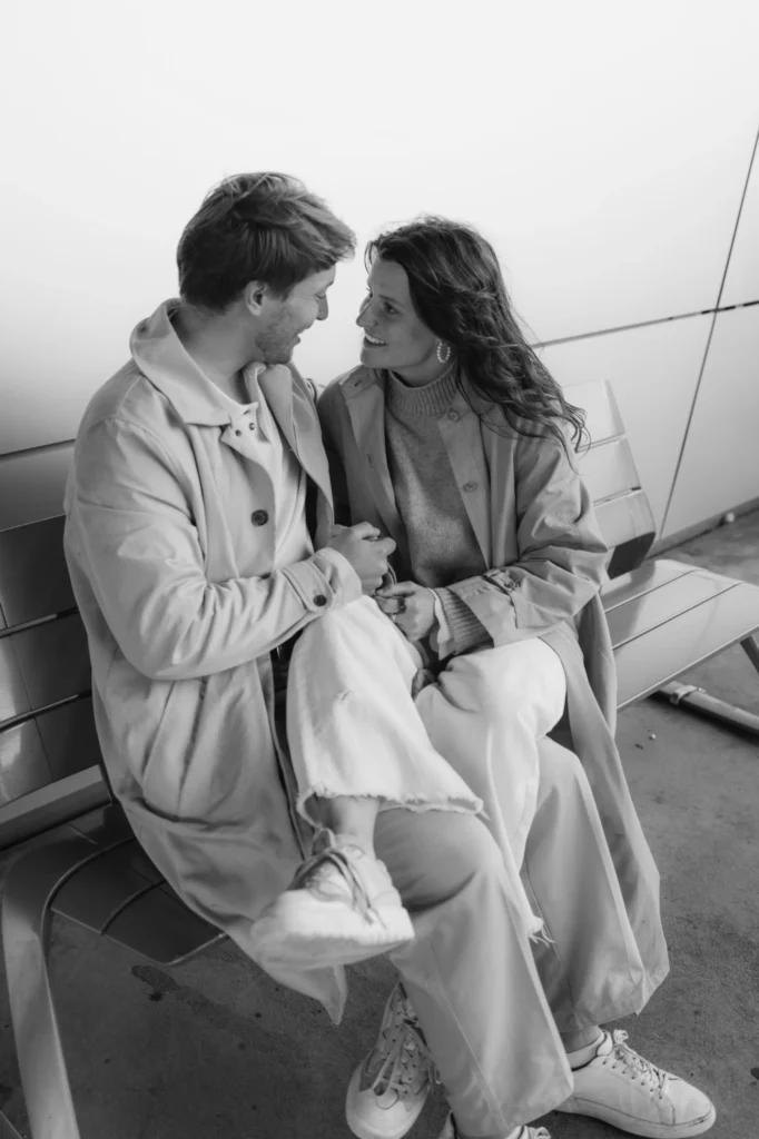 Paarfotoshooting München: Paar sitzt lächelnd auf der Bank