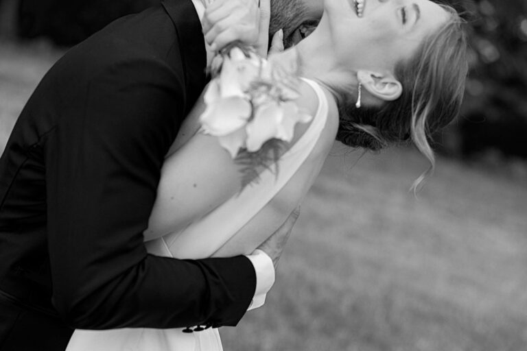 Braut wird von Bräutigam bei Hochzeitsfotoshooting geküsst sodass natürliche Hochzeitsfotos entstehen